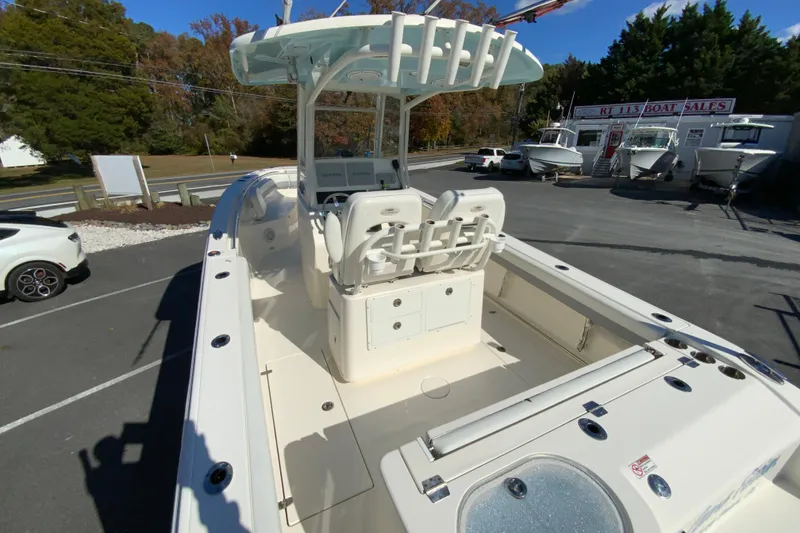 Slide: The Image of 2019 Cobia 262 Center Console boat in a dealership lot, showcasing seating and console features. - 10