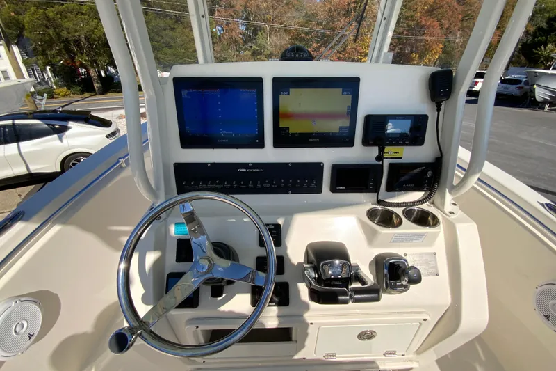 Slide: The Image of 2019 Cobia 262 Center Console boat dashboard with steering wheel and navigation screens. - 12