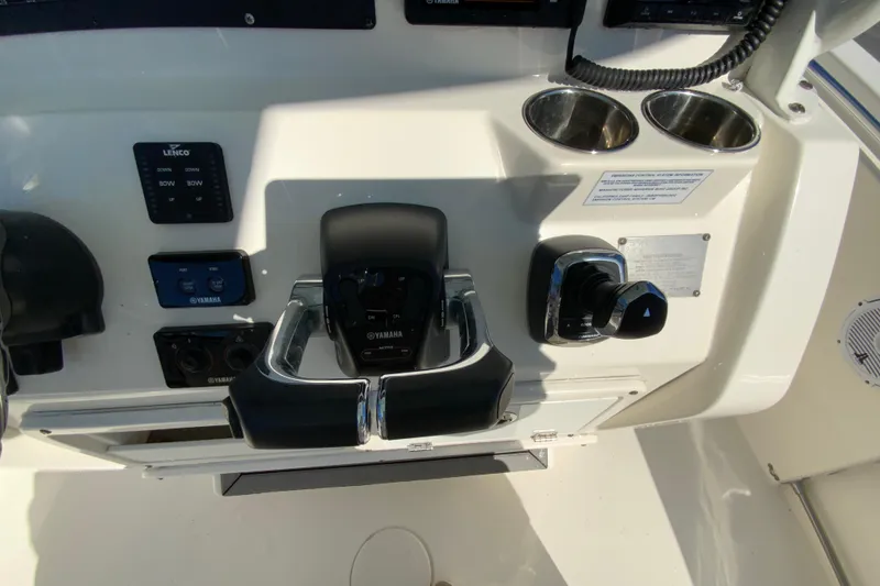 Slide: The Image of 2019 Cobia 262 Center Console boat dashboard with Yamaha controls and cup holders. - 13