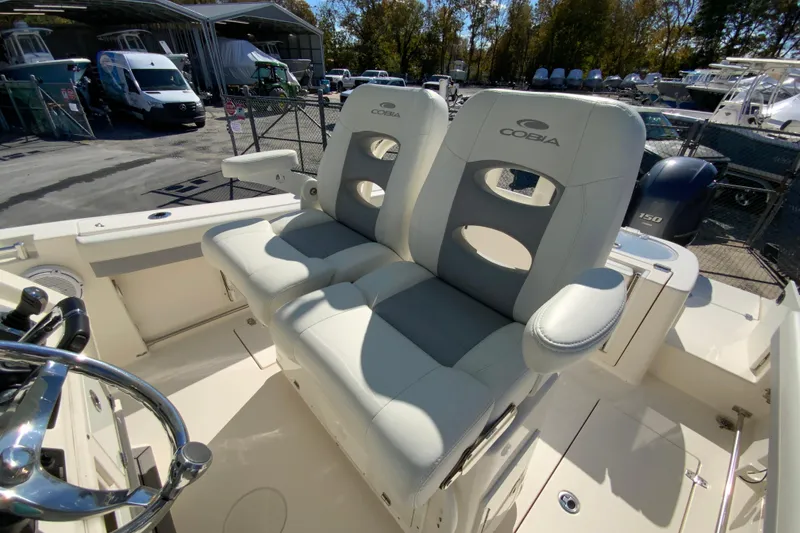 Slide: The Image of 2019 Cobia 262 Center Console boat with dual cushioned seats and steering wheel. - 15