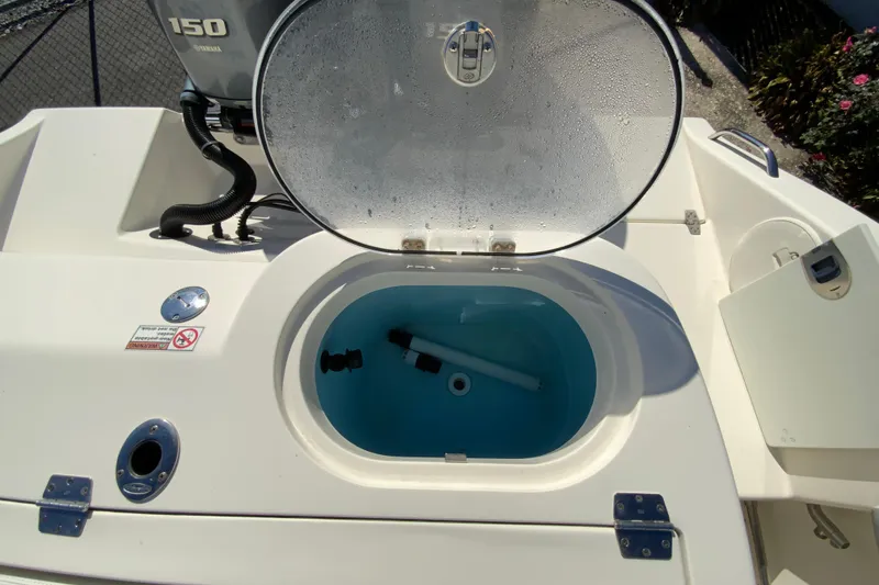 Slide: The Image of 2019 Cobia 262 Center Console livewell with open lid and Yamaha 150 engine. - 19