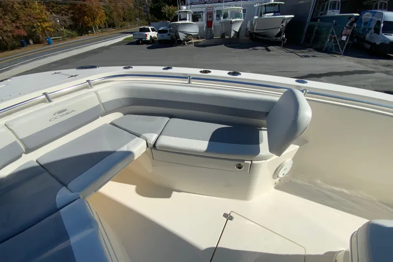 Slide: The Image of 2019 Cobia 262 Center Console boat with cushioned seating in a marina setting. - 23