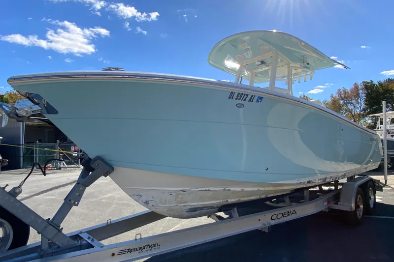 Slide: The Image of 2019 Cobia 262 Center Console boat on trailer under clear blue sky. - 5