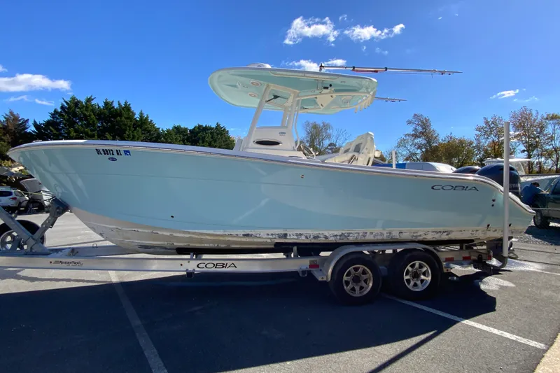 Slide: The Image of 2019 Cobia 262 Center Console boat on trailer under clear blue sky. - 6
