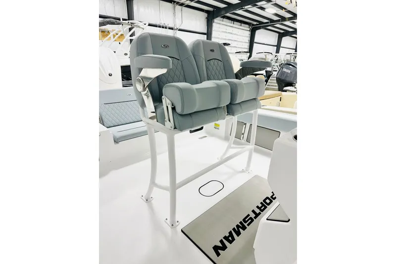 Slide: The Image of 2026 Sportsman Masters 247OE Bay Boat with dual cushioned seats in a showroom. - 5