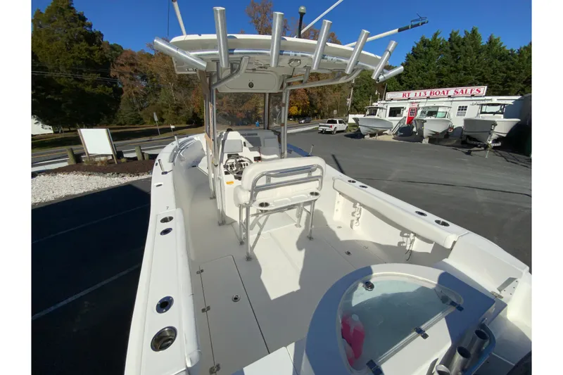 Slide: The Image of 2011 Sea Fox 256 Center Console boat at dealership, featuring spacious deck and rod holders. - 10