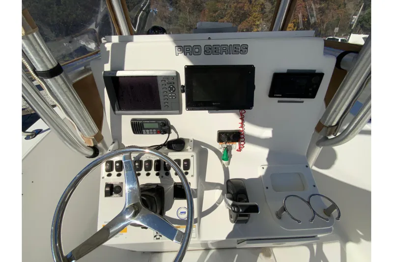 Slide: The Image of 2011 Sea Fox 256 Center Console helm with steering wheel and navigation controls. - 13