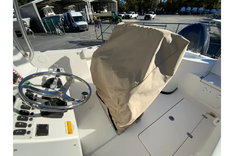 Slide: The Image of 2011 Sea Fox 256 Center Console boat interior with covered seating and steering wheel. - 28