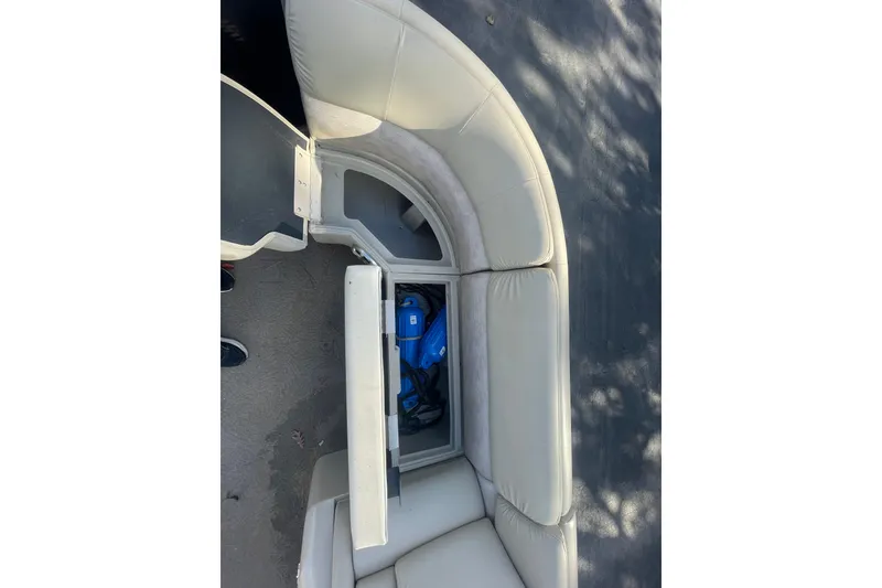 Slide: The Image of 2013 Bennington R22 boat seat storage compartment with blue life jacket inside. - 11