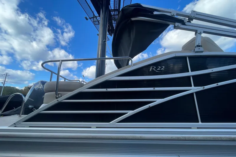 Slide: The Image of 2013 Bennington R22 boat with sleek design against a blue sky backdrop. - 15