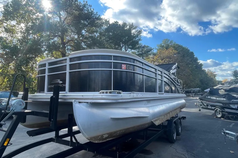 Slide: The Image of 2013 Bennington R22 pontoon boat on trailer under a sunny sky. - 3