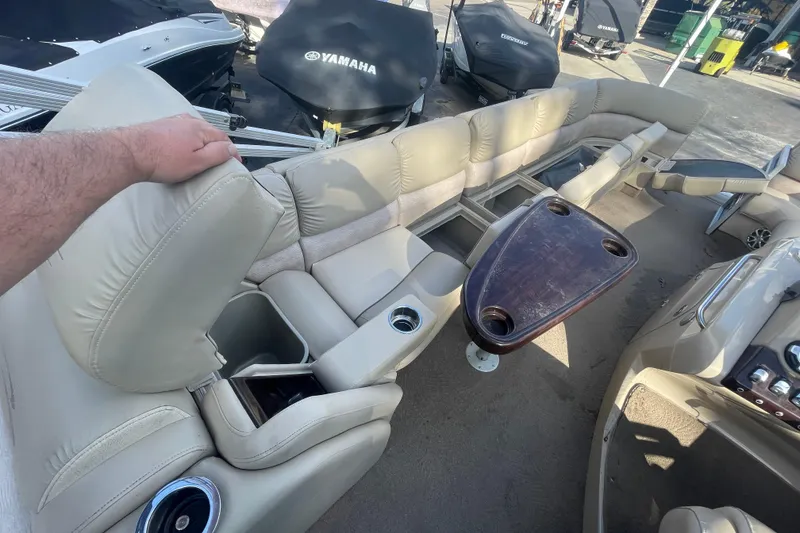 Slide: The Image of 2013 Bennington R22 boat interior with beige seating and wooden table. - 7