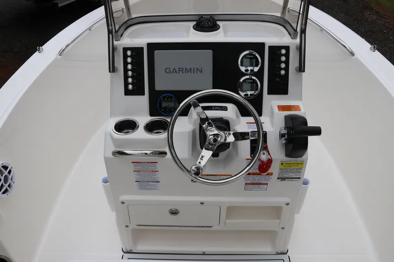 Slide: The Image of 2026 Robalo R180 Center Console boat dashboard with Garmin display and steering wheel. - 23