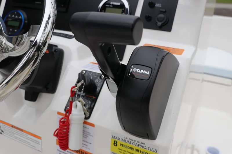 Slide: The Image of 2026 Robalo R180 Center Console boat controls with Yamaha throttle and steering wheel. - 27