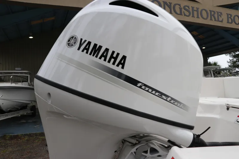 Slide: The Image of 2026 Robalo R180 Center Console with Yamaha four-stroke engine at a boat dealership. - 8