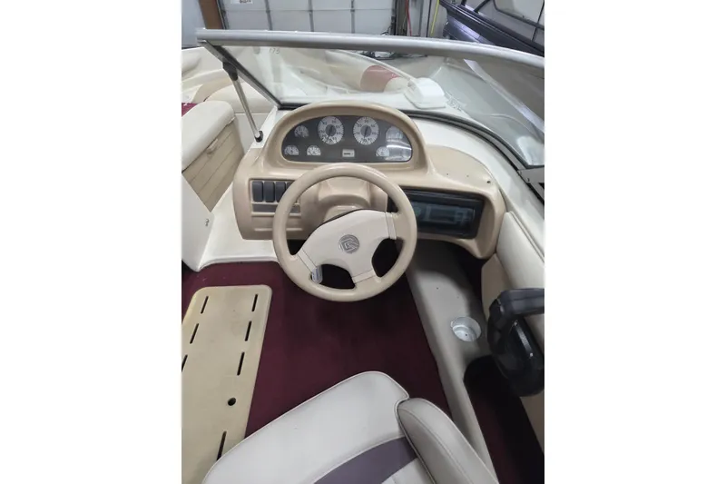 Slide: The Image of Interior of a 1996 Glastron SX175 boat, featuring white and beige seating with a windshield. - 5