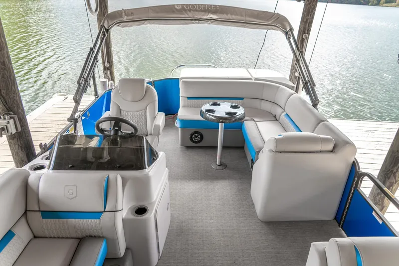 Slide: The Image of 2021 Godfrey Sweetwater 2286 C pontoon boat interior with plush seating and steering console. - 15