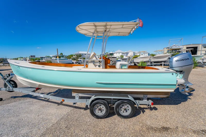 Slide: The Image of 2005 Oyster Bay 23 boat on trailer with Honda outboard motor, parked outdoors. - 10