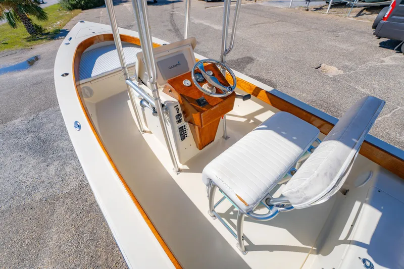 Slide: The Image of 2005 Oyster Bay 23 boat interior with steering wheel and seating, parked on pavement. - 14