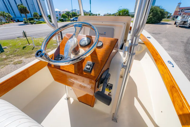 Slide: The Image of 2005 Oyster Bay 23 boat helm with wooden console and steering wheel. - 17
