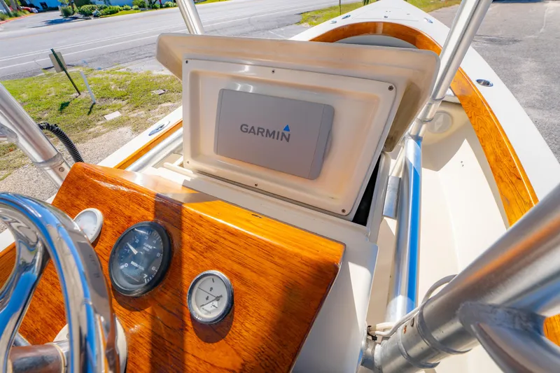 Slide: The Image of 2005 Oyster Bay 23 boat dashboard with Garmin navigation system and wooden accents. - 18