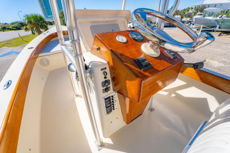Slide: The Image of 2005 Oyster Bay 23 boat helm with wooden console and steering wheel. - 19