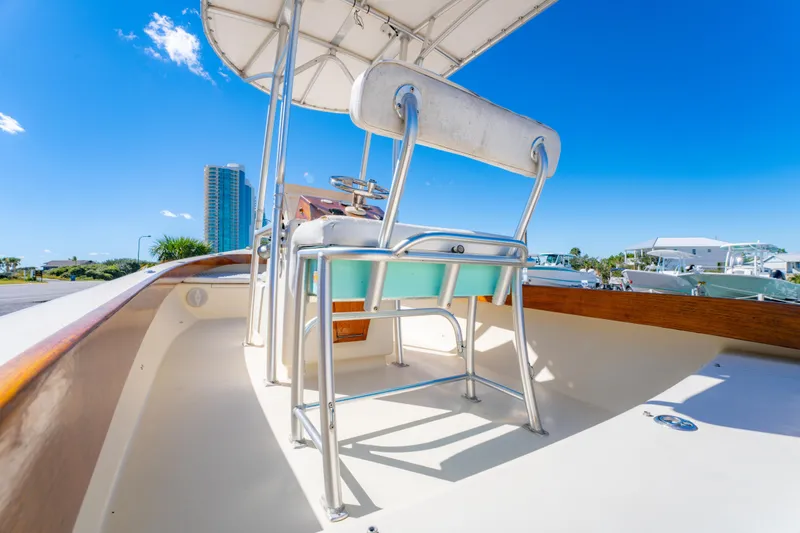 Slide: The Image of 2005 Oyster Bay 23 boat interior with seating, under clear blue sky. - 21