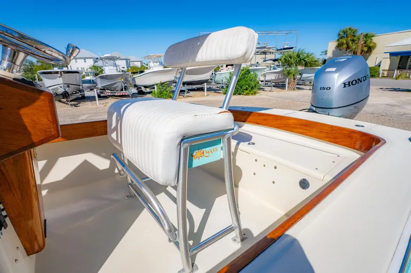 Slide: The Image of 2005 Oyster Bay 23 boat interior with white seating and Honda outboard motor. - 22