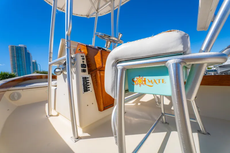 Slide: The Image of 2005 Oyster Bay 23 boat interior with steering console and cushioned seating. - 23