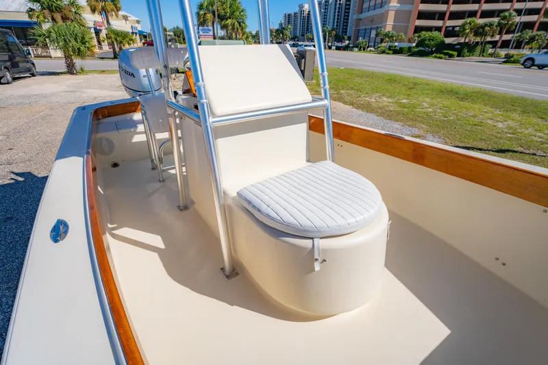 Slide: The Image of 2005 Oyster Bay 23 boat interior with seating and console, parked near a road. - 26
