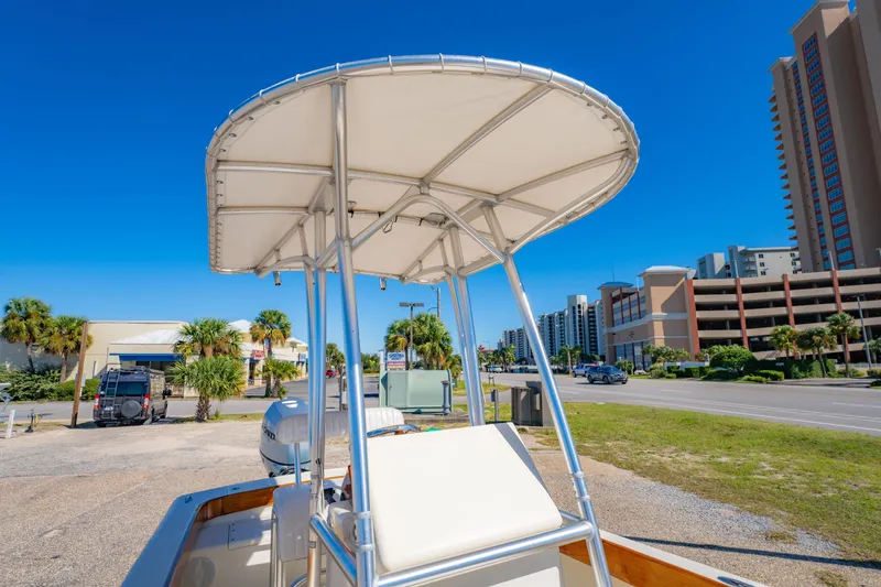 Slide: The Image of 2005 Oyster Bay 23 boat with T-top, parked near coastal buildings and palm trees. - 27