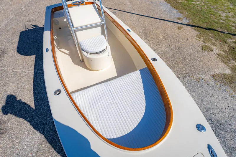 Slide: The Image of 2005 Oyster Bay 23 boat interior with white seating and wooden trim. - 29