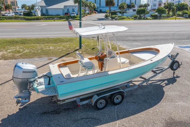 Slide: The Image of 2005 Oyster Bay 23 boat on trailer with Honda outboard motor, parked near road. - 3