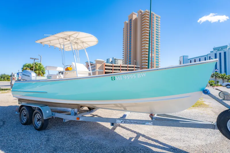 Slide: The Image of 2005 Oyster Bay 23 boat on trailer, cityscape background, clear blue sky. - 4