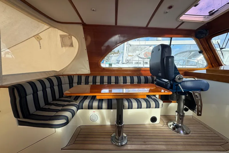 Slide: The Image of Interior of 2001 Hinckley Talaria 44 yacht with striped seating and wooden table. - 16
