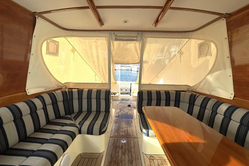 Slide: The Image of Interior of 2001 Hinckley Talaria 44 yacht with striped seating and wooden table. - 18