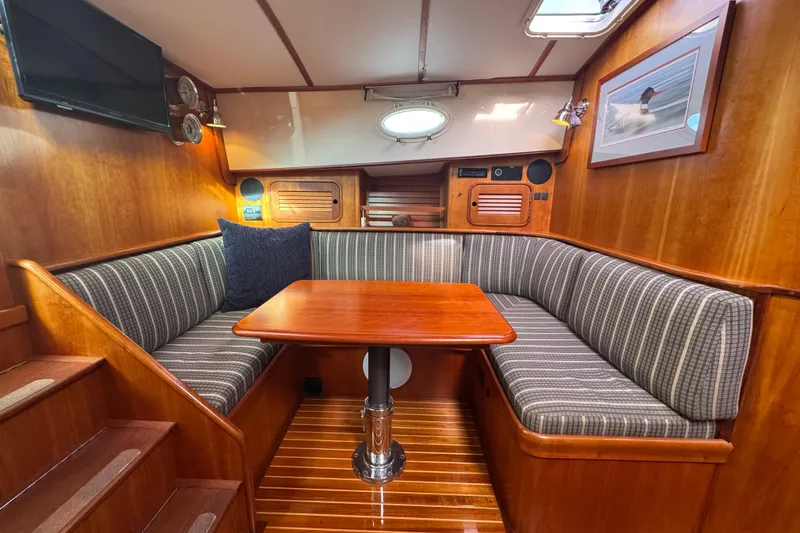 Slide: The Image of Hinckley Talaria 44 yacht interior, 2001 model, featuring a cozy dining area with striped seating. - 2