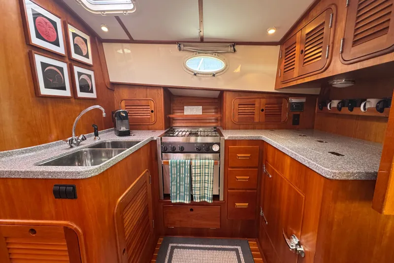 Slide: The Image of Luxurious 2001 Hinckley Talaria 44 yacht kitchen with wood cabinetry and modern appliances. - 23
