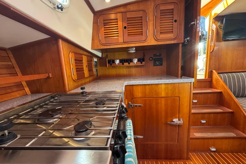 Slide: The Image of Hinckley Talaria 44 yacht interior kitchen with wooden cabinetry and stainless steel stove, 2001 model. - 25