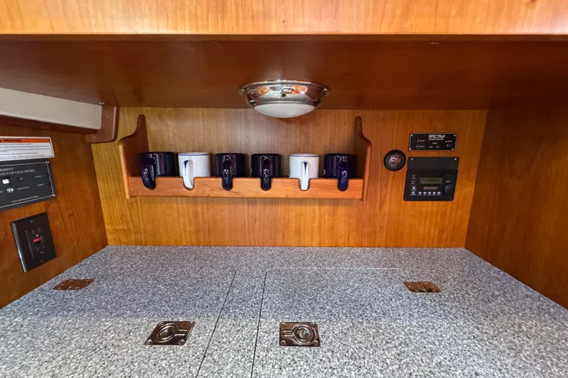 Slide: The Image of Hinckley Talaria 44 yacht interior, 2001 model, featuring wooden cabinetry and countertop with mugs. - 26