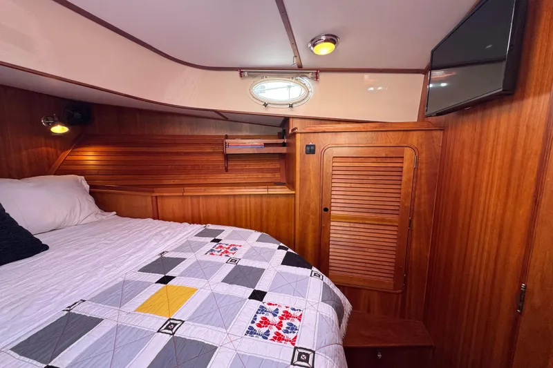 Slide: The Image of Cozy cabin interior of 2001 Hinckley Talaria 44 with wood paneling and quilted bedspread. - 32