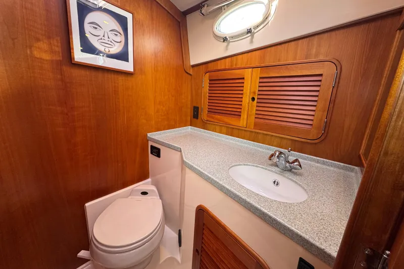 Slide: The Image of 2001 Hinckley Talaria 44 yacht bathroom with wood paneling, sink, and toilet. - 35