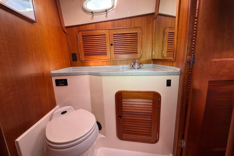 Slide: The Image of Hinckley Talaria 44 yacht bathroom, featuring wooden cabinetry and modern fixtures, 2001 model. - 36