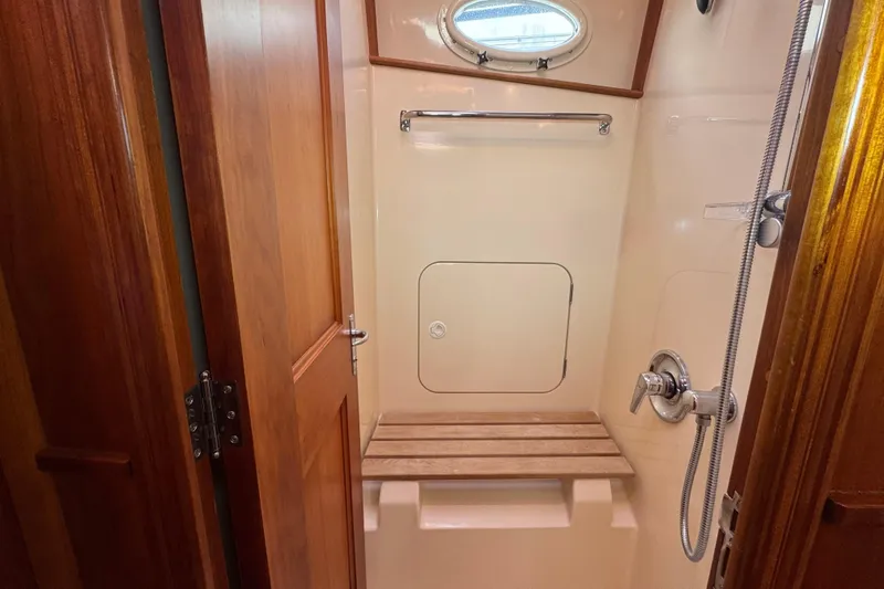 Slide: The Image of Shower area in 2001 Hinckley Talaria 44 yacht with wooden bench and porthole. - 37