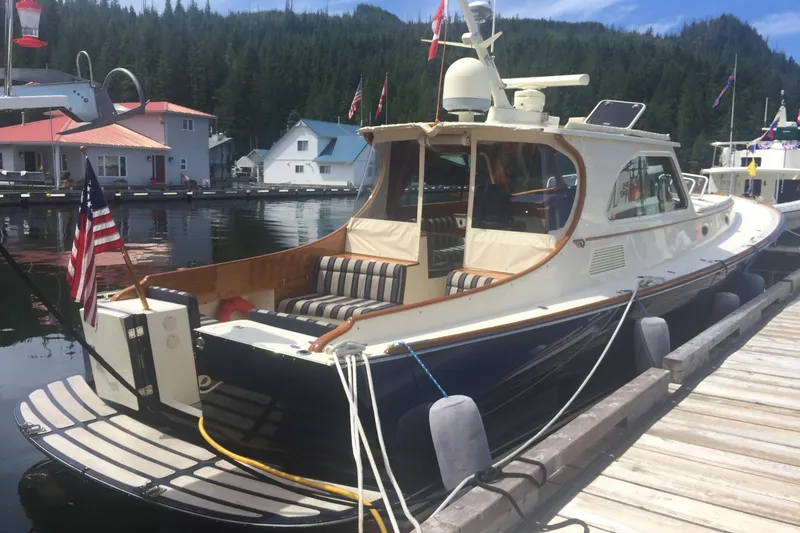 Slide: The Image of Hinckley Talaria 44 yacht docked, 2001 model, with American flag, scenic marina background. - 5