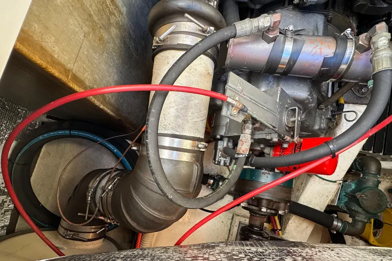 Slide: The Image of Engine compartment of a 2001 Hinckley Talaria 44 boat, showing hoses and mechanical components. - 53