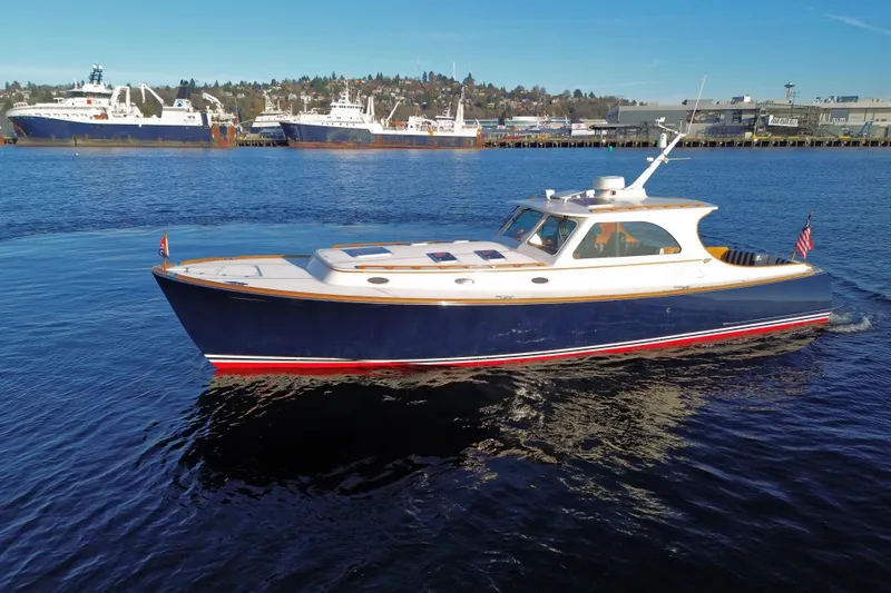Slide: The Image of 2001 Hinckley Talaria 44 yacht cruising on calm waters, with a scenic harbor backdrop. - 7