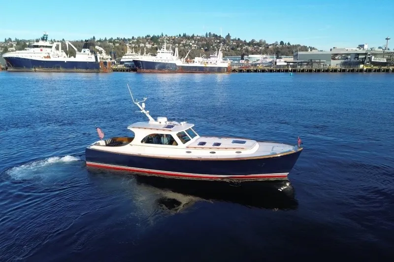 Slide: The Image of 2001 Hinckley Talaria 44 yacht cruising in a scenic harbor setting. - 8