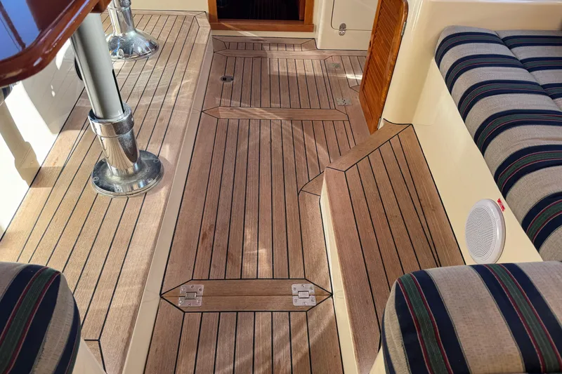 Slide: The Image of Hinckley Talaria 44 yacht interior, featuring teak flooring and striped seating, 2001 model. - 19