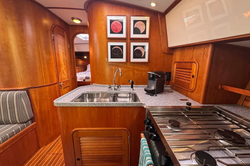 Slide: The Image of Hinckley Talaria 44 yacht interior, featuring a modern kitchen with wood accents, 2001 model. - 24